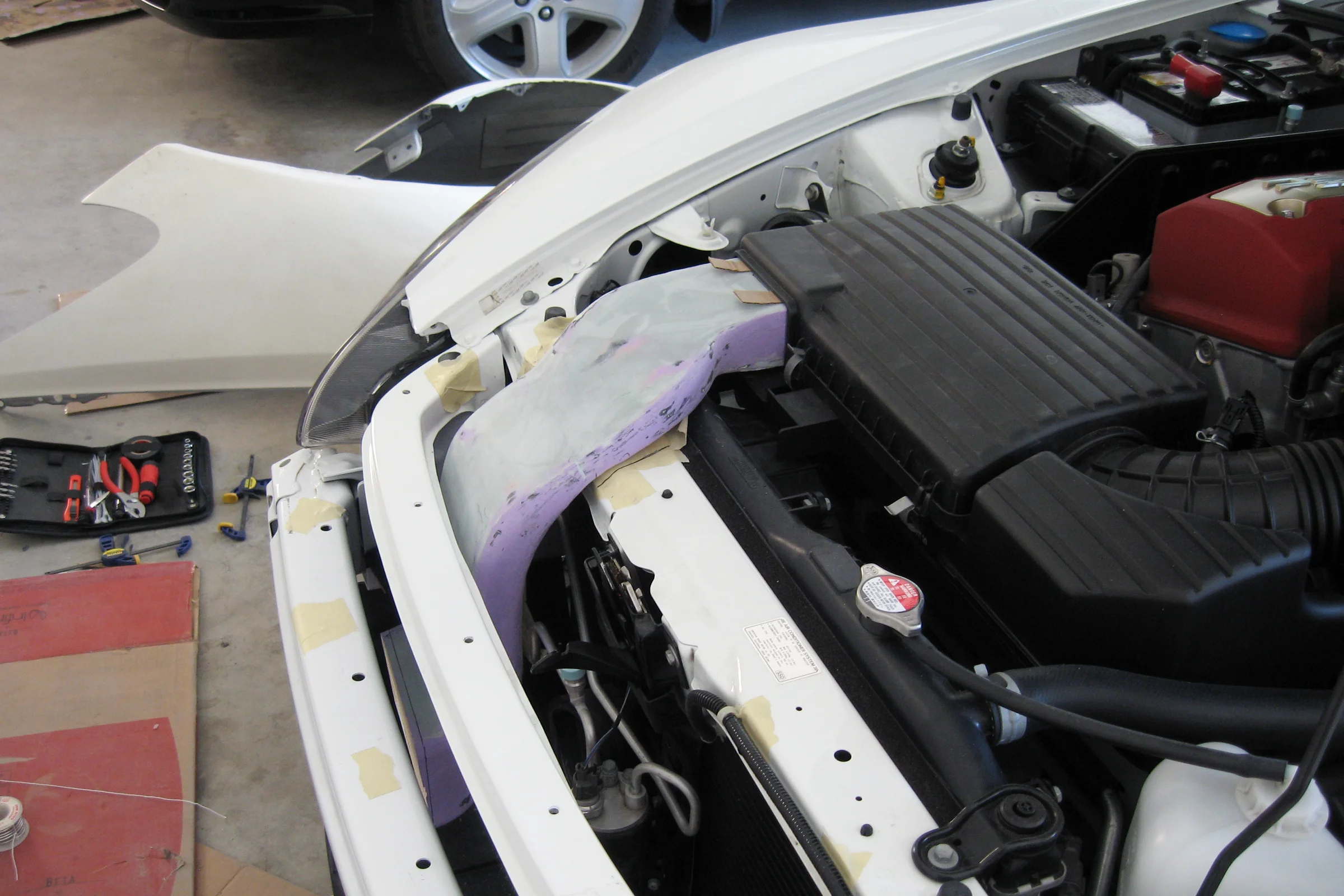 S2000 Fabrication Program — foam constraint study fitted in engine bay at radiator support pinch point
