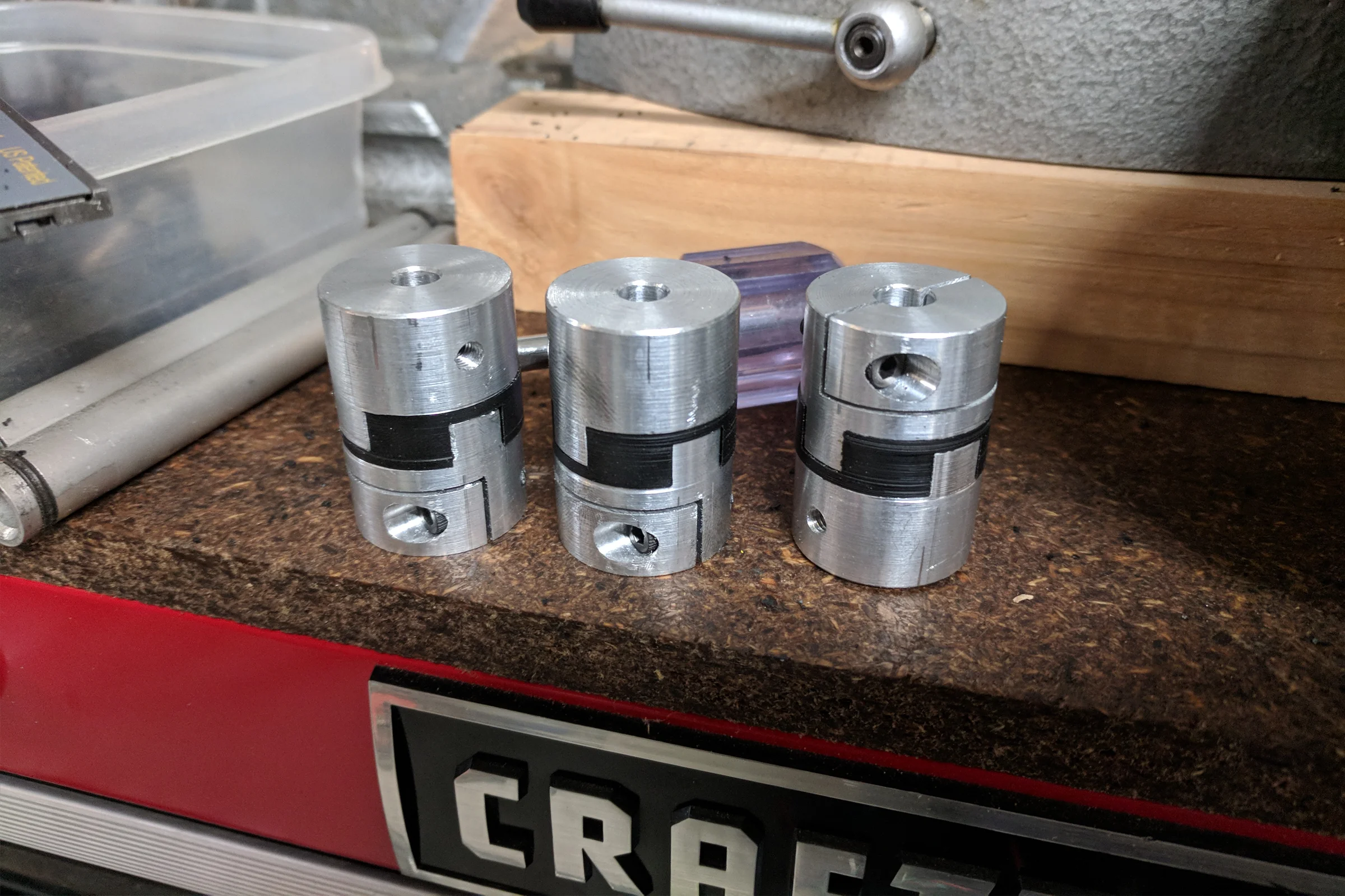 The Mill Trilogy — Oldham coupling components laid out: aluminum flanges and Delrin center sliding disk machined from raw stock